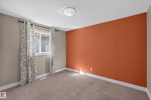 Neutral-toned carpeting, white trim, window with blinds, and a ceiling-mounted light fixture - 1850 Rutherford Road Sw, Edmonton, AB 