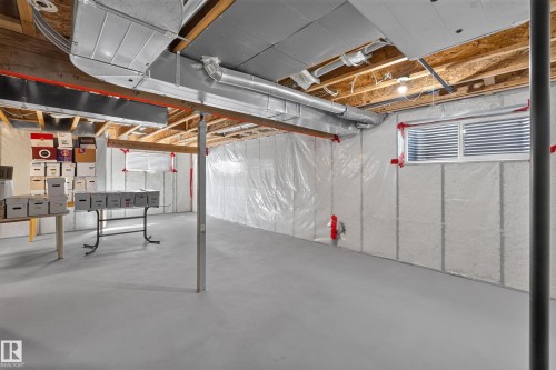 Unfinished basement with concrete flooring, exposed ceiling joists, and visible ductwork - 1850 Rutherford Road Sw, Edmonton, AB 