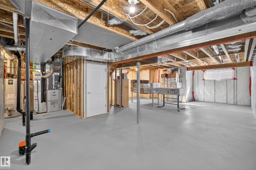 Unfinished basement with exposed ceiling joists, concrete flooring, insulated walls, and visible utility systems - 1850 Rutherford Road Sw, Edmonton, AB 