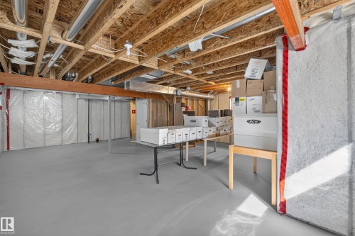 Basement with exposed wood joists and subflooring, insulated walls, and a painted concrete floor - 1850 Rutherford Road Sw, Edmonton, AB 