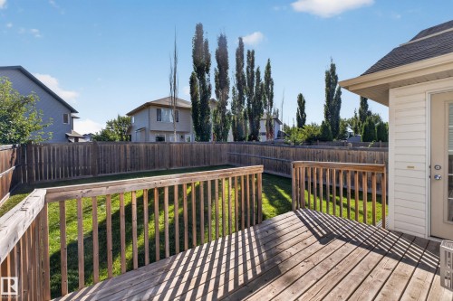 Wood deck with railing, fenced backyard, and manicured lawn - 1850 Rutherford Road Sw, Edmonton, AB 