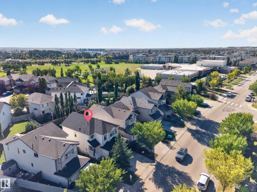 Residential property with a gabled roof and light-colored siding, situated on a tree-lined street - 1850 Rutherford Road Sw, Edmonton, AB 