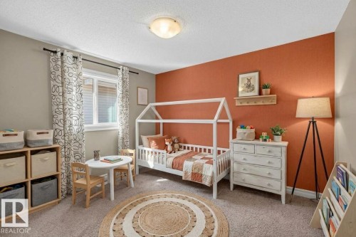 Plush carpeted flooring, a large window, and a built-in storage unit with cubbies - 1850 Rutherford Road Sw, Edmonton, AB 