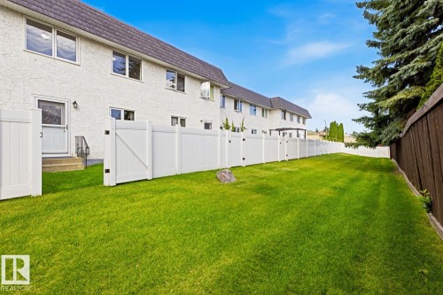 Expansive green lawn enclosed by white panel fencing - 11317 22 Avenue Nw, Edmonton, AB 