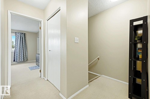 Neutral wall paint, carpeted flooring, built-in closet, and an interior window with natural light - 11317 22 Avenue Nw, Edmonton, AB 