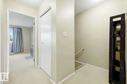 Neutral wall paint, carpeted flooring, built-in closet, and an interior window with natural light - 