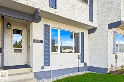 Stucco exterior with contrasting trim, permanent address numbering, and established landscaping - 