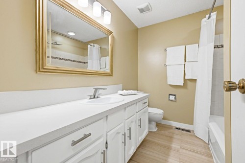 White vanity with brushed nickel hardware, a white countertop, and an undermount sink - 11317 22 Avenue Nw, Edmonton, AB 