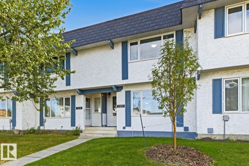Stucco exterior with contrasting trim, multiple large windows, and a dark shingle roof - 11317 22 Avenue Nw, Edmonton, AB 