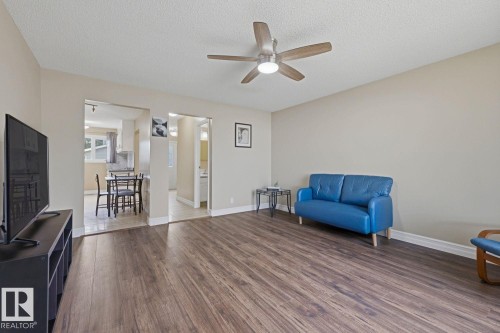 Wood-finish flooring throughout, complemented by a ceiling fan with integrated lighting - 11317 22 Avenue Nw, Edmonton, AB 