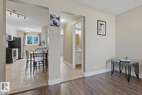 Wood-finish flooring throughout the main area and tile flooring in the kitchen and hallway - 11317 22 Avenue Nw, Edmonton, AB 