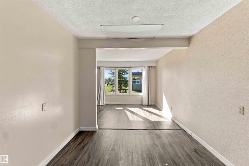 Wood-finish flooring throughout, with a window bank featuring an exterior landscape - 17351 85 Avenue Nw, Edmonton, AB 