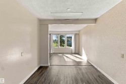 Wood-finish flooring throughout, with a window bank featuring an exterior landscape - 