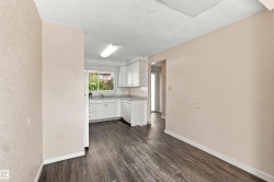 Kitchen featuring white cabinetry, a sink, and dark wood-finish flooring - 