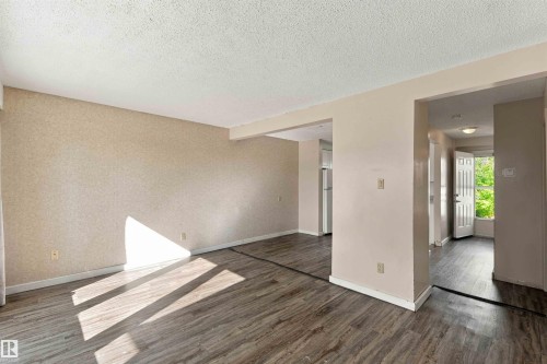Spacious room featuring wood-finish flooring and neutral wall tones - 17351 85 Avenue Nw, Edmonton, AB 