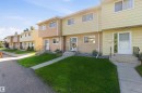 Row of townhomes featuring light-colored siding and concrete walkways - 17351 85 Avenue Nw, Edmonton, AB 