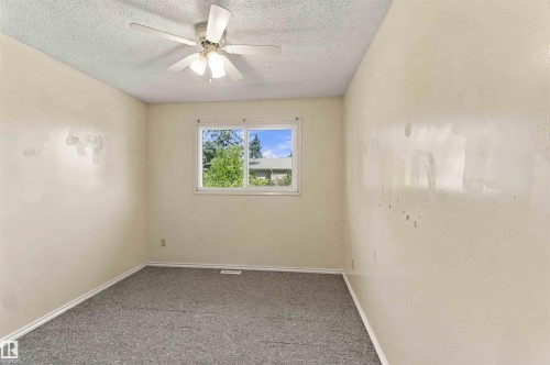 Window with natural light, textured ceiling, ceiling fan with light kit, and wall-to-wall carpeting - 17351 85 Avenue Nw, Edmonton, AB 