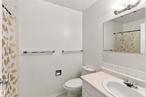 Bathroom featuring a vanity with a laminate countertop, integrated sink, and chrome faucet - 17351 85 Avenue Nw, Edmonton, AB 