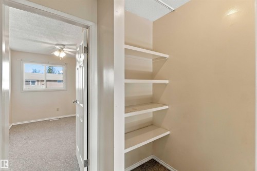 Built-in shelving, neutral wall paint, ceiling fan, and carpeted flooring - 17351 85 Avenue Nw, Edmonton, AB 