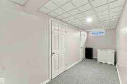 Finished lower level with paneled doors, carpet flooring, a drop ceiling, and a high window - 