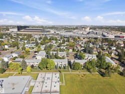 Expansive neighborhood setting with residential buildings, mature trees, and a nearby stadium - 