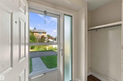 Entryway featuring a paneled door, screen door with clear glass, and a frosted sidelight - 