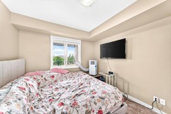 Recessed ceiling detail, neutral wall paint, window with white trim, wall-mounted television, and carpeted flooring - 