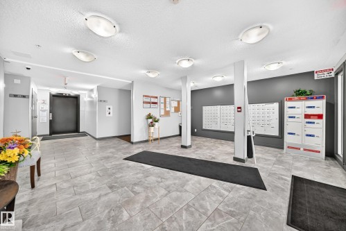 Building entry with gray-toned tile flooring, recessed overhead lighting, and an elevator access - #306 5370 Chappelle Rd Sw, Edmonton, AB 