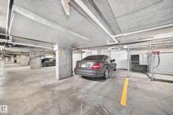 Concrete parking garage with marked spaces and overhead utility lines - 