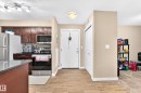 Kitchen featuring dark wood-finish cabinetry, stainless steel appliances, and a gray countertop on the island - #306 5370 Chappelle Rd Sw, Edmonton, AB 
