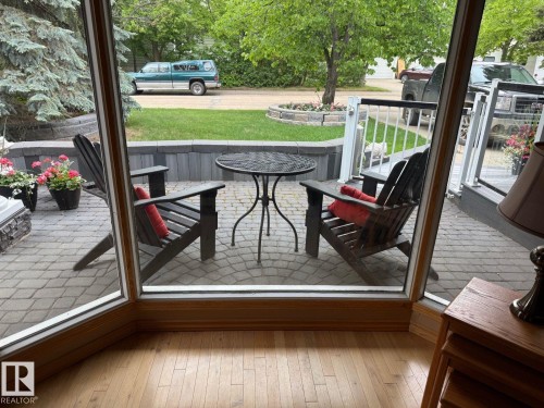 Bay window with wood-finish flooring offering a patio with paver stones and a stone retaining wall - 29 Lindbergh Crescent, St. Albert, AB 
