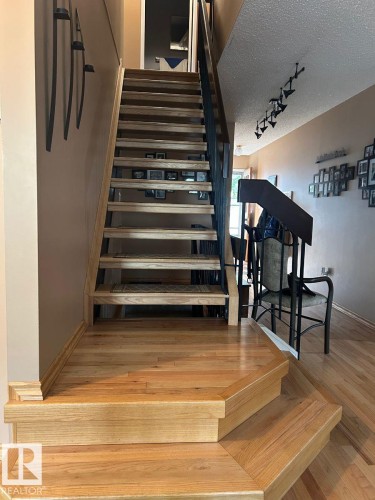 Hardwood flooring, wood stairs with open risers, and a sleek black metal railing - 29 Lindbergh Crescent, St. Albert, AB 