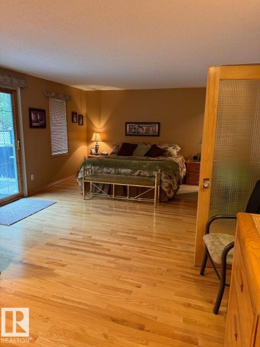 Hardwood flooring throughout, sliding glass door, and a paneled door with textured glass - 29 Lindbergh Crescent, St. Albert, AB 