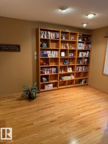 Built-in wood-finish shelving, recessed ceiling lighting, and natural wood-finish flooring - 29 Lindbergh Crescent, St. Albert, AB 