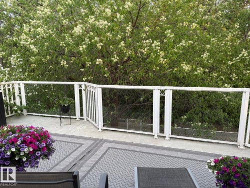Expansive outdoor deck featuring composite decking, white aluminum railings, and clear glass panels - 29 Lindbergh Crescent, St. Albert, AB 