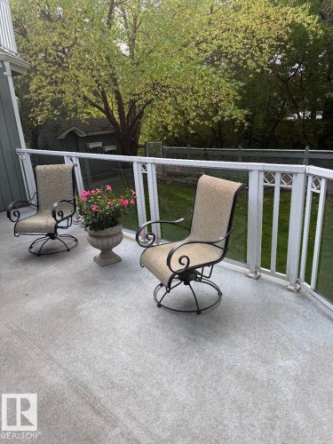 Concrete patio with a white railing system, featuring glass panels - 29 Lindbergh Crescent, St. Albert, AB 