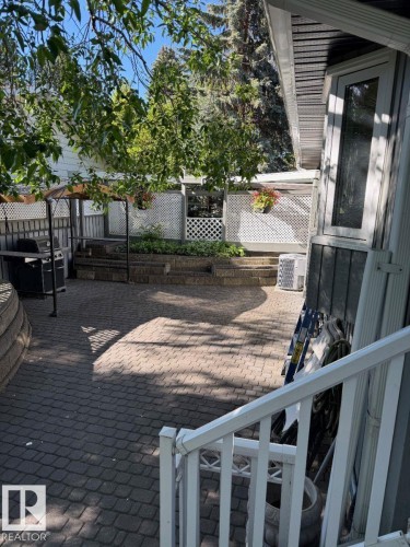 Expansive patio with paver surfacing, tiered landscaping, and privacy lattice - 29 Lindbergh Crescent, St. Albert, AB 