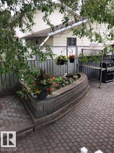 Paver patio and walkway with a stone-block raised planter - 29 Lindbergh Crescent, St. Albert, AB 