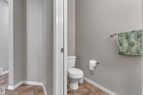 Powder room featuring a toilet, wall-mounted towel bar, and a wall-mounted toilet paper holder - 3230 21A Avenue Nw, Edmonton, AB 