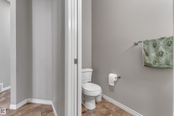 Powder room featuring a toilet, wall-mounted towel bar, and a wall-mounted toilet paper holder - 