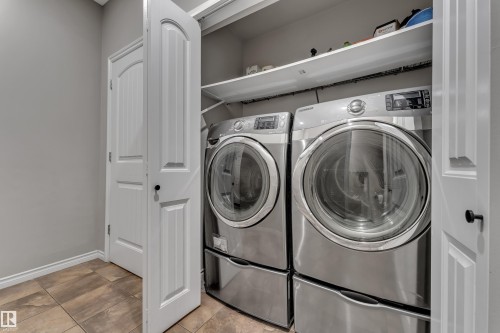 Laundry closet with tile flooring and built-in shelving - 3230 21A Avenue Nw, Edmonton, AB 