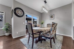 Hardwood-finish flooring, neutral wall paint, and a contemporary linear pendant light fixture - 