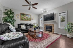 Living area featuring wood-finish flooring, a ceiling fan, and recessed lighting - 