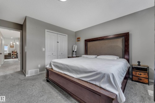 Carpeted flooring, neutral wall paint, and white bi-fold closet doors - 3230 21A Avenue Nw, Edmonton, AB 
