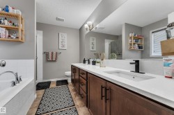 Double vanity with black hardware, white rectangular sinks, and an extended mirror - 