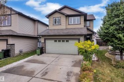 Two-story property with attached garage, concrete driveway, and stone veneer accents - 