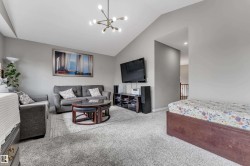 Vaulted ceiling with modern chandelier and recessed lighting - 