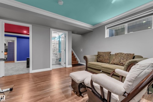 Wood-finish flooring, two distinct doorways, a window with blinds, and white crown molding - 3230 21A Avenue Nw, Edmonton, AB 