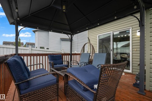 Expansive outdoor deck with a permanent pergola structure, integrated string lighting, and direct access through a sliding glass door - 3230 21A Avenue Nw, Edmonton, AB 
