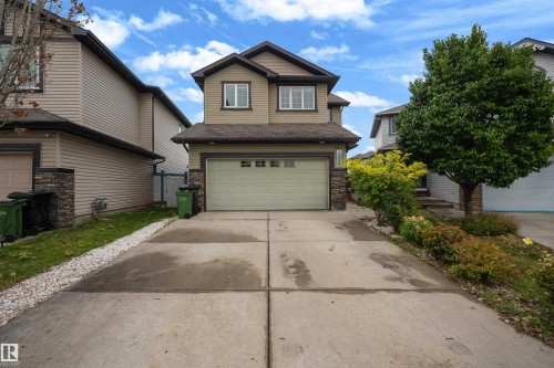 Two-story residence featuring a front-facing garage, stone veneer accents, and a concrete driveway - 3230 21A Avenue Nw, Edmonton, AB 